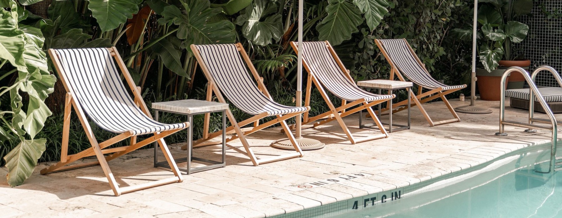 a pool with chairs and umbrellas by it